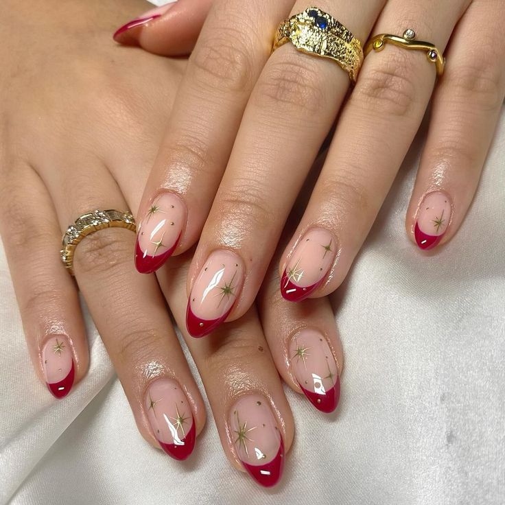 Elegant Nude and Deep Red Nail Design with Glossy Tips and Gold Star Accents.