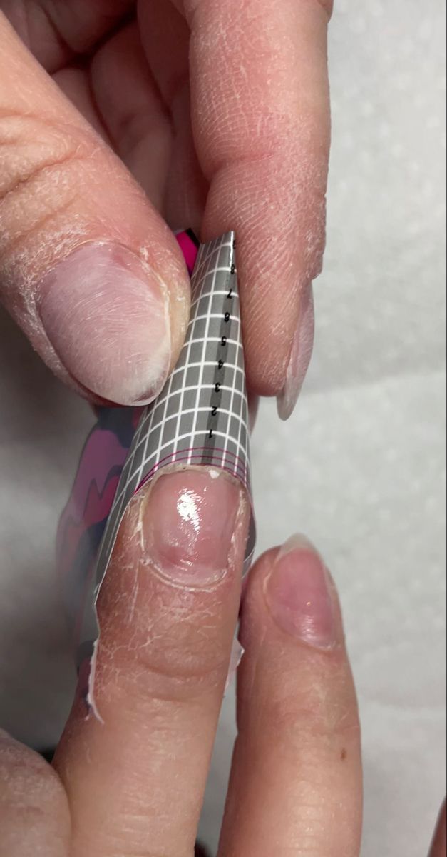 Nail Enhancement: Precision in Applying Clear Forms for Sculpted Extensions.