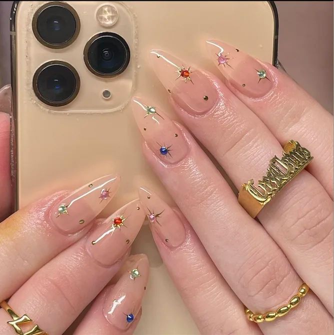 Celestial-Inspired Elegant Nail Design with Nude Base and Colorful Gem Accents