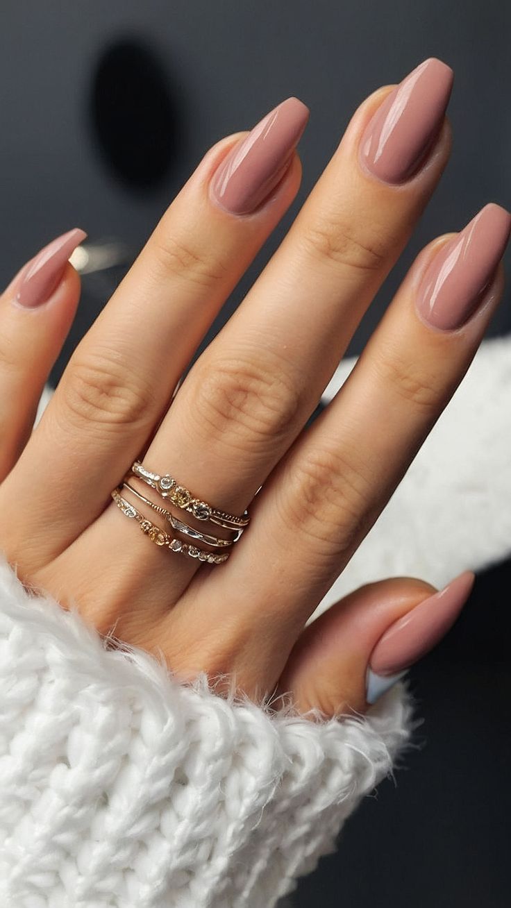 Sophisticated Almond-Shaped Manicure in Peachy Nude with Elegant Gold Accents.