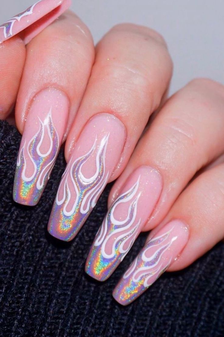 Striking Flame-Inspired Nail Design: Soft Pink Base with Intricate White Patterns and Holographic Detailing.