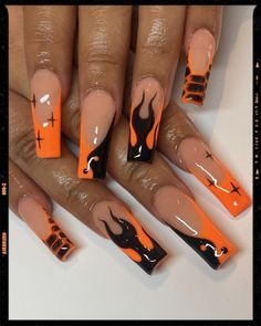 Dramatic Orange and Black Flame Nail Design with Subtle Nude Background