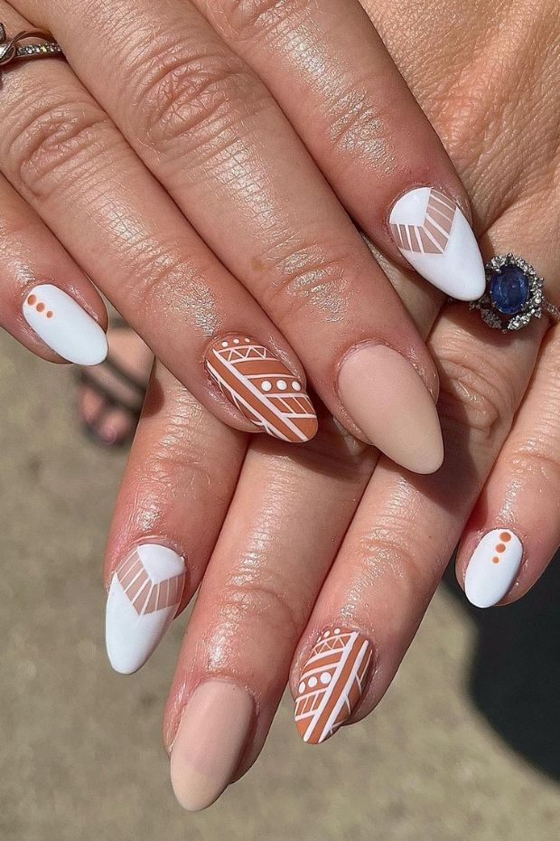 Chic Almond-Shaped Nail Design with Nude and White Geometric Patterns.