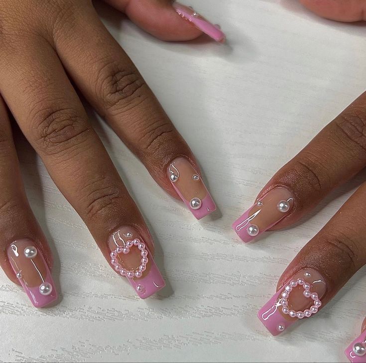 Elegant Pink Nail Design with Glossy Finish and Intricate Pearl Embellishments.