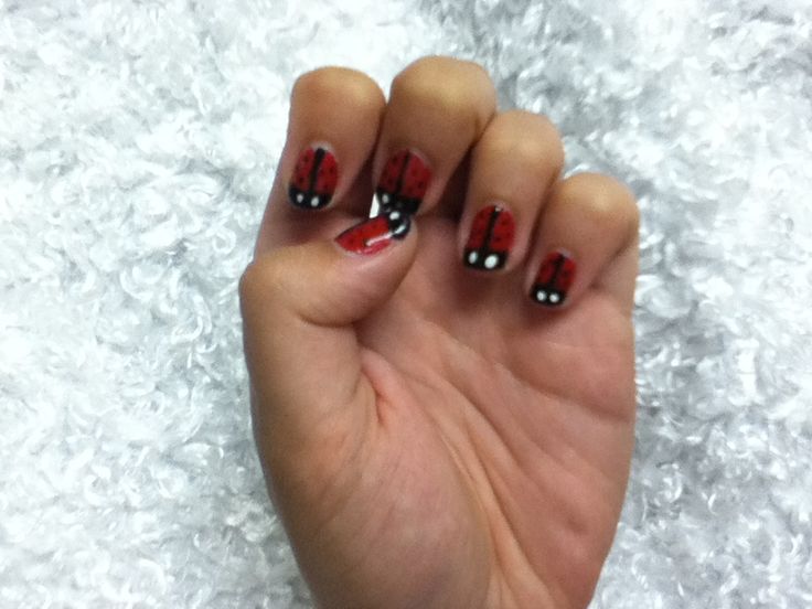 Playful Ladybug-Inspired Nail Design with Glossy Red and Black Polka Dots.