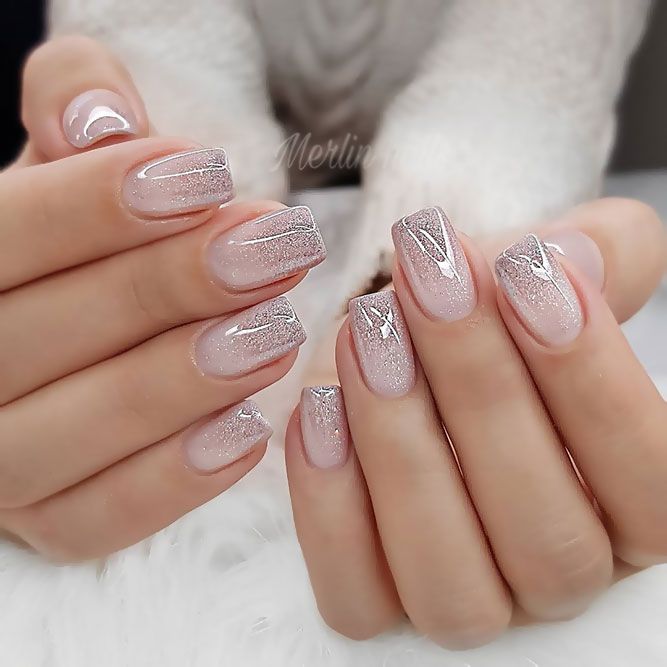 Sophisticated Ombre Nail Design: Sheer Pink to Sparkling Silver with Geometric Accents.