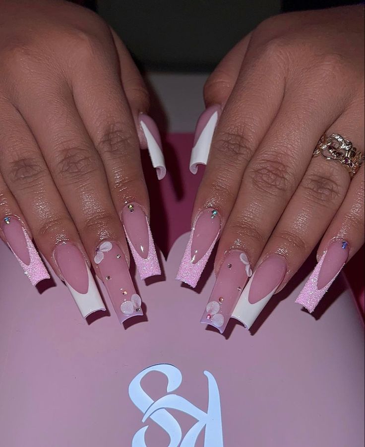 Chic Soft Pink and White Floral Nail Design with Glamorous Embellishments.