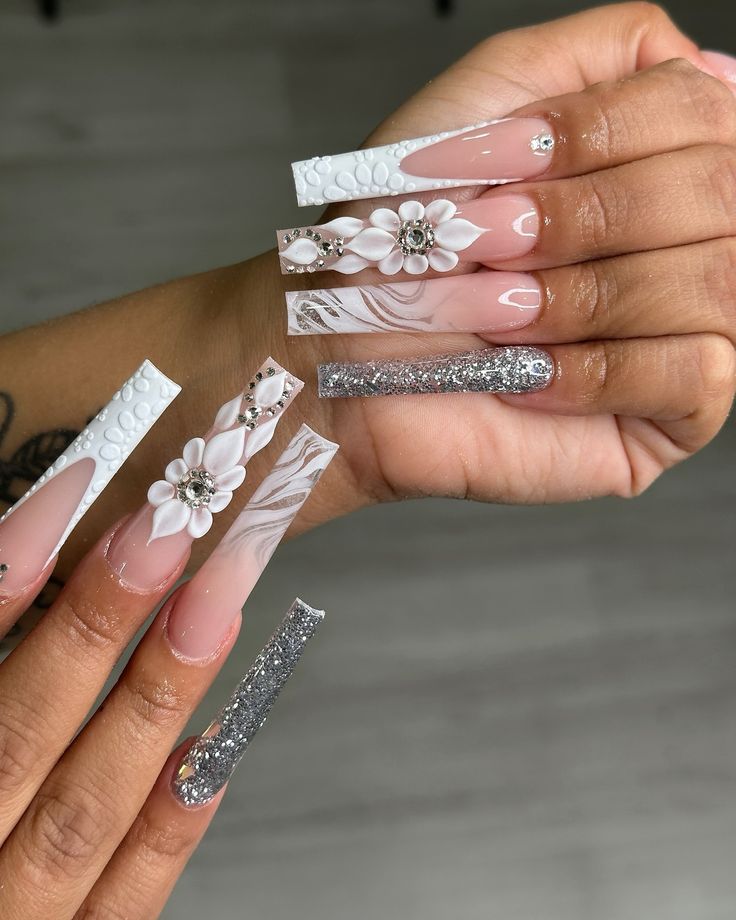 Chic Long Sculpted Nails with Floral Accents and Sparkling Silver Finish.