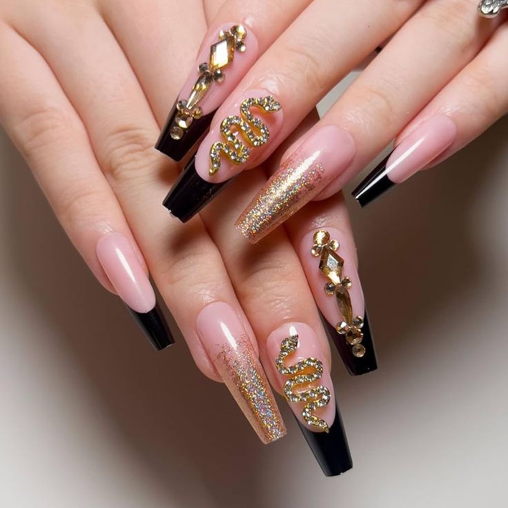 Elegant Glamorous Nail Design with Black Tips, Nude Base, and Sparkling Gold Accents.