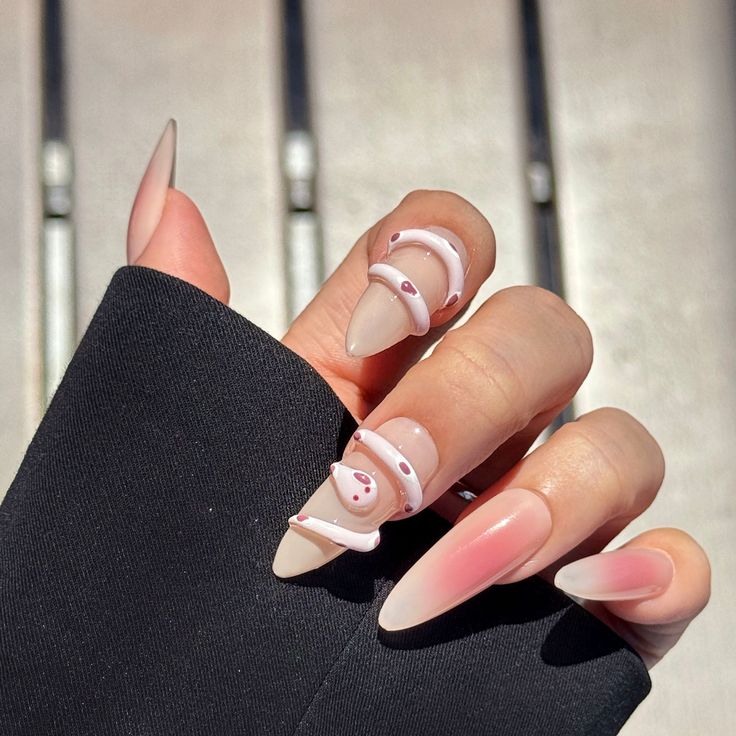 Chic Almond-Shaped Nail Design with Playful Embellishments and Glossy Finishes.