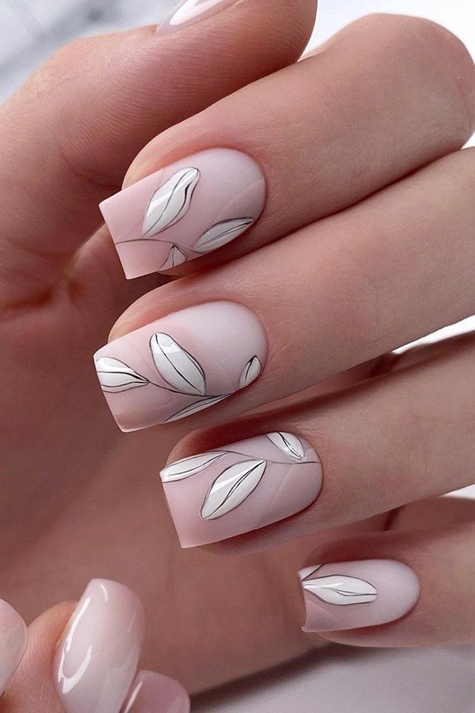 Chic Nude Nail Design with White Leaf Accents and Mixed Finishes.