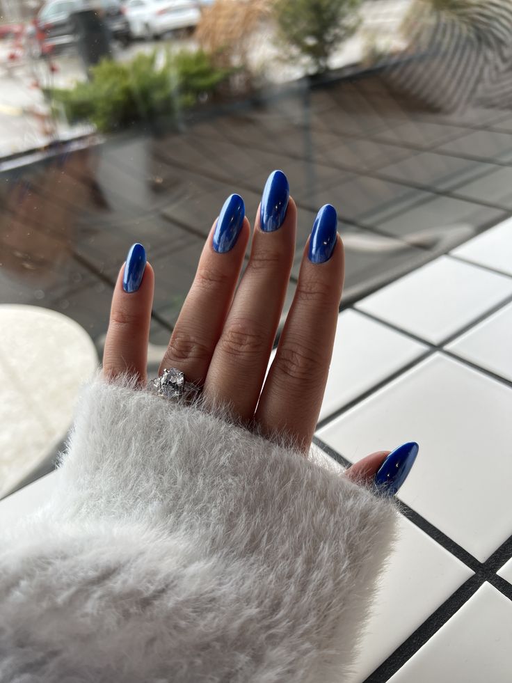 Chic Vibrant Blue Nails Pair Perfectly with a Cozy Sweater for a Stylish Casual Look.