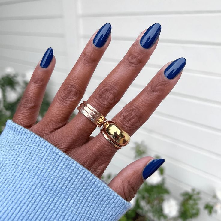 Elegant Navy Blue Almond-Shaped Nails Enhance Chic Style with Gold Accents.