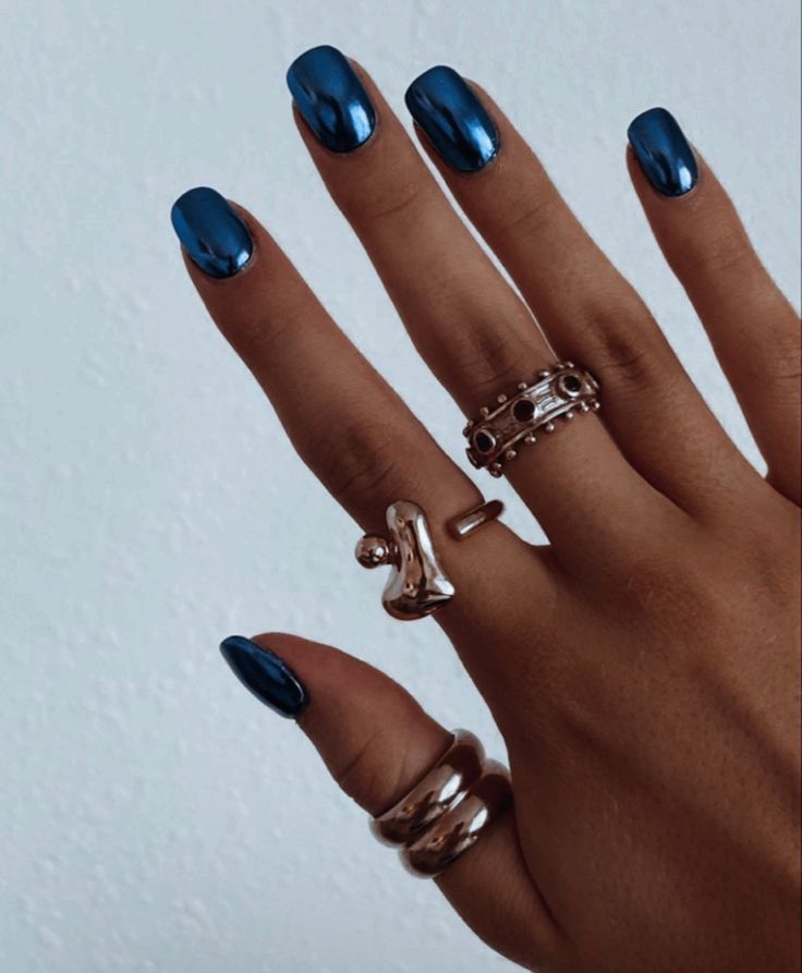 Elegant Shiny Cobalt Blue Nail Design Paired with Stylish Rings for a Bold, Fashionable Look.