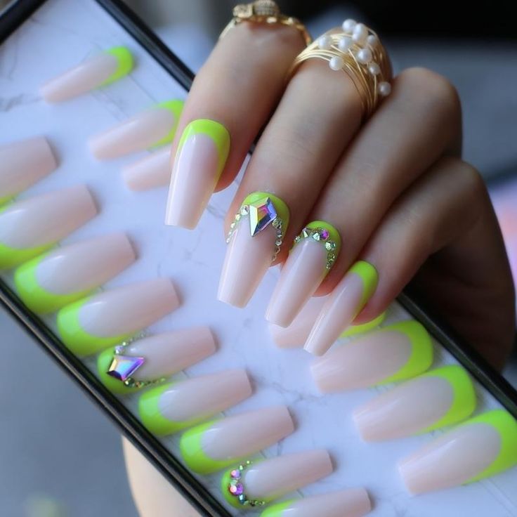 Captivating Manicure: Soft Nude and Neon Green Tips with Geometric Rhinestone Detail.