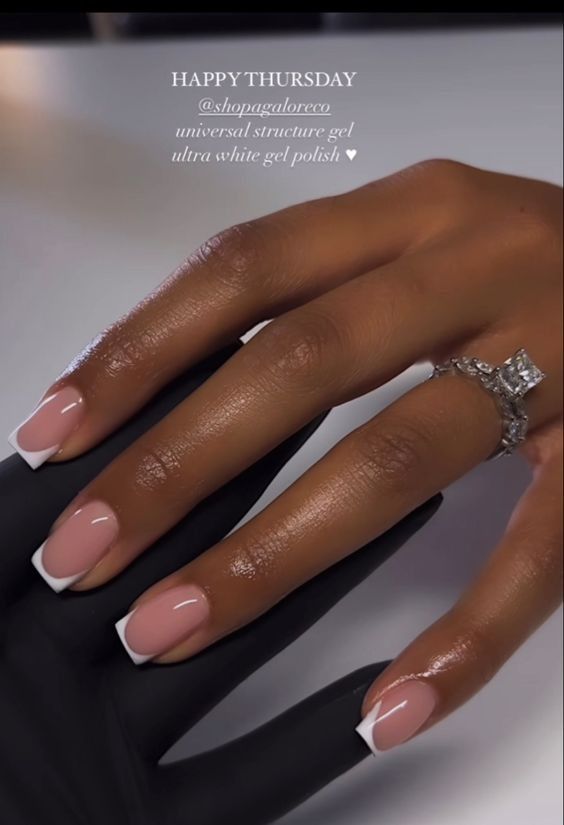 Sophisticated Nude and White French Manicure Elevated by Glamorous Ring.