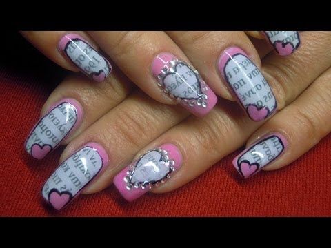 Charming Pink and Gray Nail Design with Heart Motifs and Artistic Text Patterns.