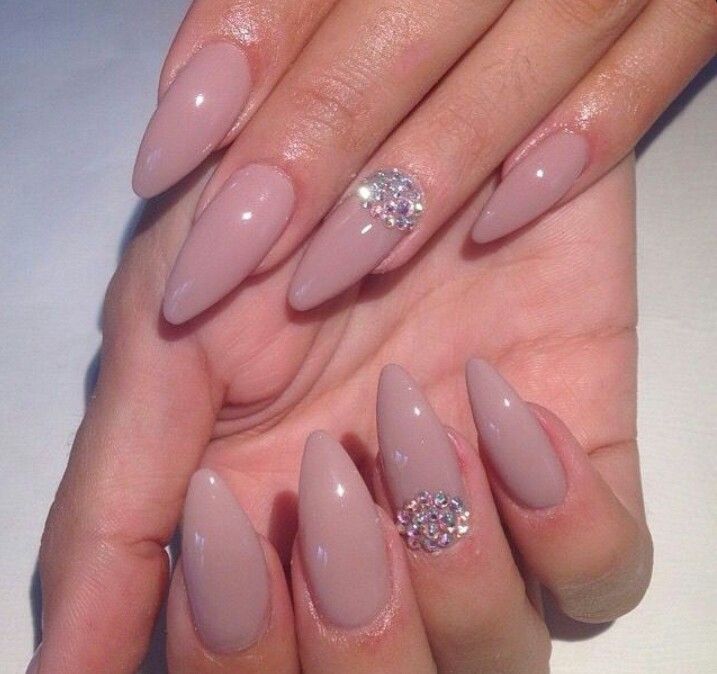 Chic Almond-Shaped Nails in Soft Nude with Glamorous Gem Accent.