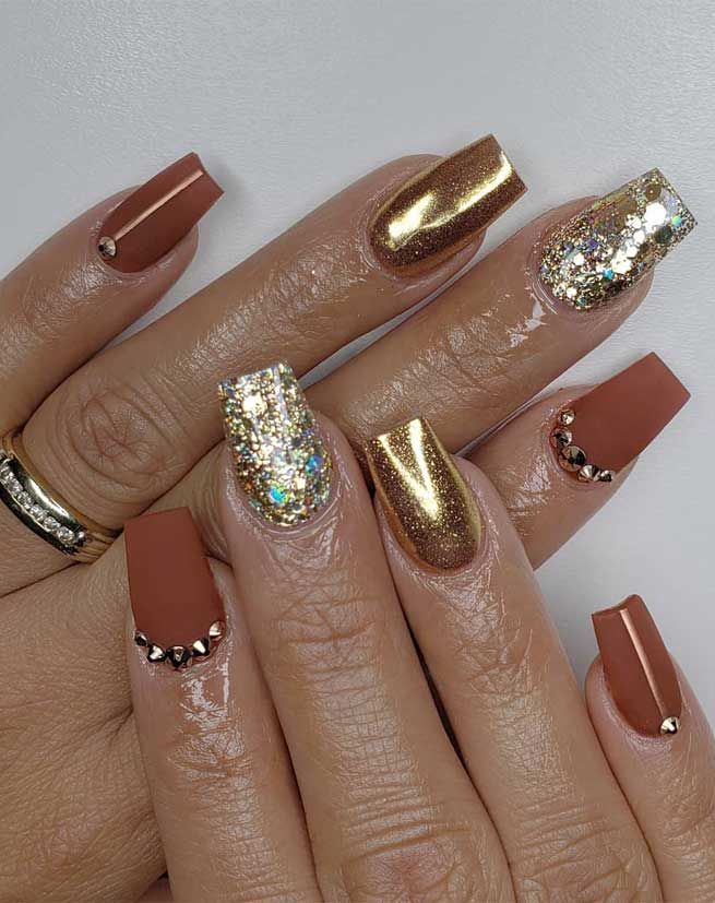 Chic Nail Design: Matte Rust with Glamorous Gold and Elegant Metallic Accents.