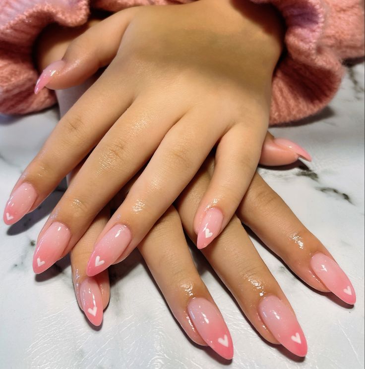 Elegant Almond-Shaped Nails with Soft Pink Gradient and Playful Heart Designs.