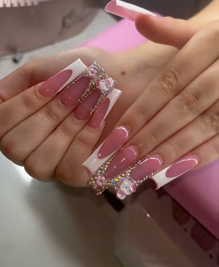 Elegant Pink and White Stiletto Nail Art with Jewel Accents and Playful Motifs.