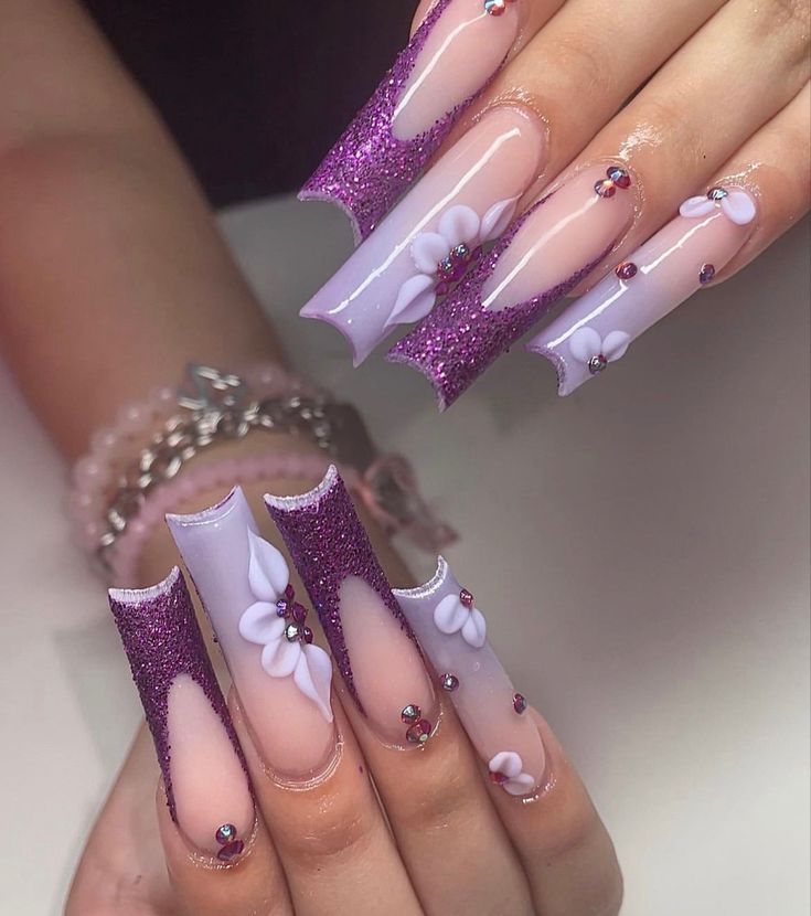 Chic Lavender Nails Adorned with Glitter, Floral Accents, and Gemstones.