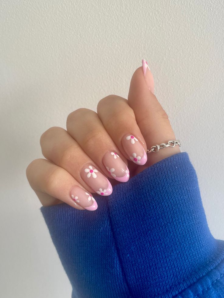 Playful Floral Nail Design: Soft Pink French Tips with Charming White and Pink Accents