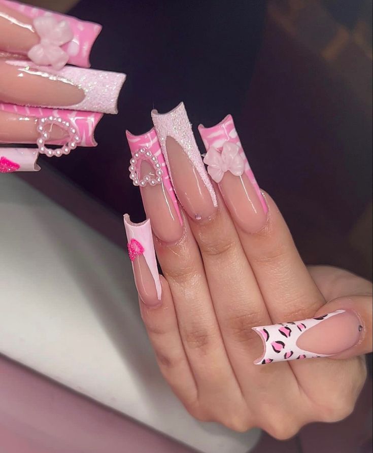 Chic Pink Nail Design with Intricate Patterns and Embellishments.