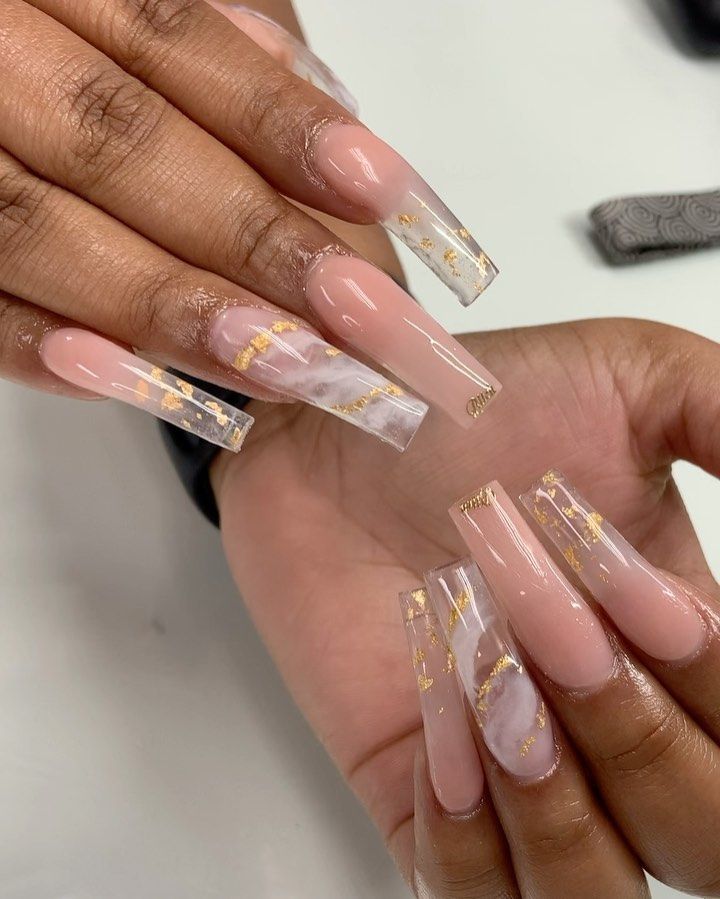 Luxurious Long Square Nail Design with Marbled Pattern and Gold Accents on Soft Nude Base.