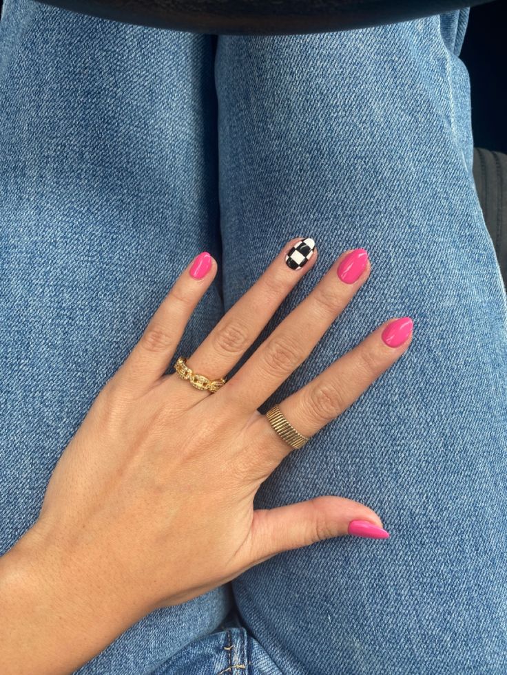 Trendy Vibrant Pink Manicure with Edgy Checkerboard Accent Nail and Gold Rings.