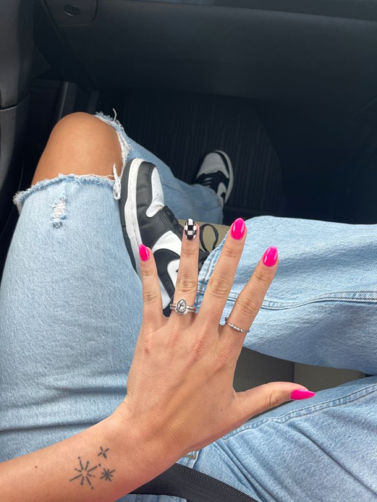 Bold Pink Nails with Playful Accents Elevate Casual Denim Style.