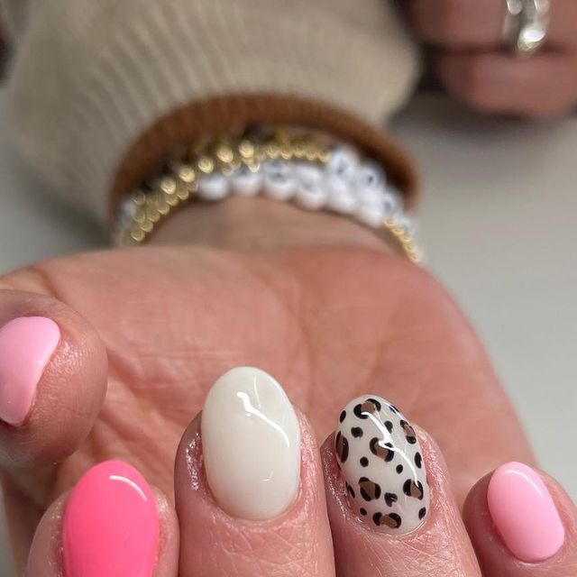 Trendy Pastel Pink Nail Design with Chic White Accent and Bold Animal Print.