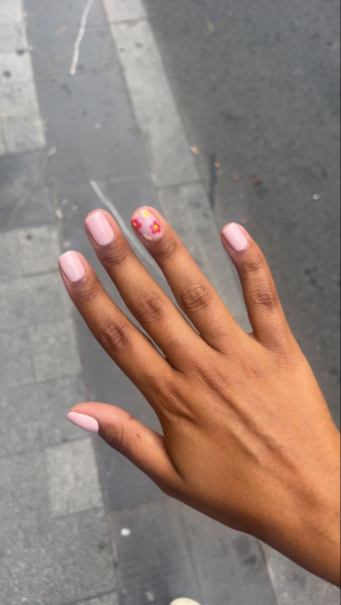 Elegant Soft Pink Nail Design with Playful Floral Accent for Versatile Occasions