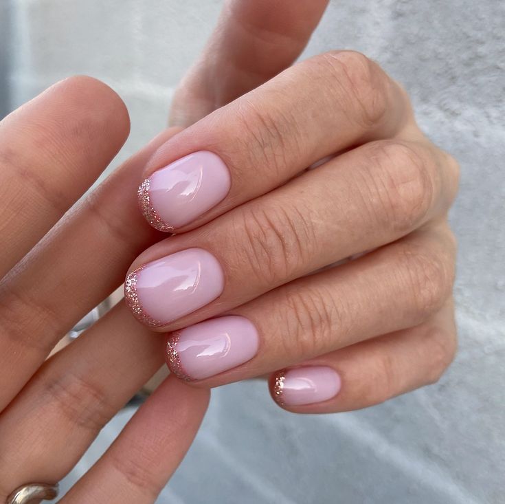 Chic Pastel Pink Nail Design with Glitter French Tips for Elegant Glamour.