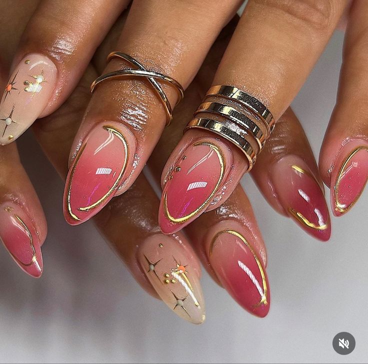 Sophisticated Stiletto Nails: Soft Pink and Nude Gradient with Delicate Gold and Floral Accents.