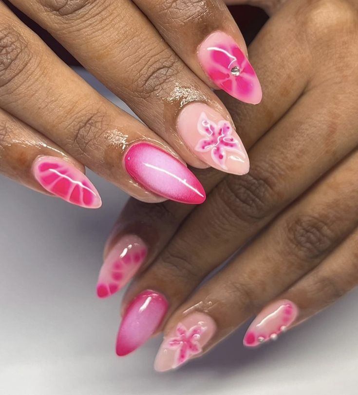 Stunning Ombre Nail Design: Gradient Pink to Fuchsia with Floral Motifs and Elegant Rhinestones.