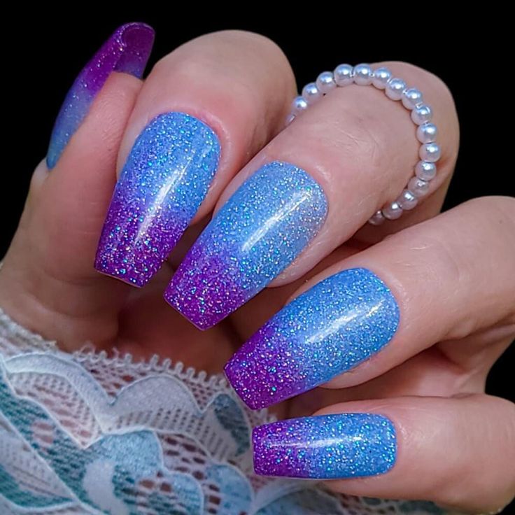 Stunning Sparkling Ombre Nails: Vibrant Purple to Soft Blue with Glittering Allure.