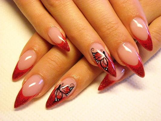 Captivating Stiletto Nails: Soft Nude Base with Striking Red Tips and Whimsical Butterfly Designs.