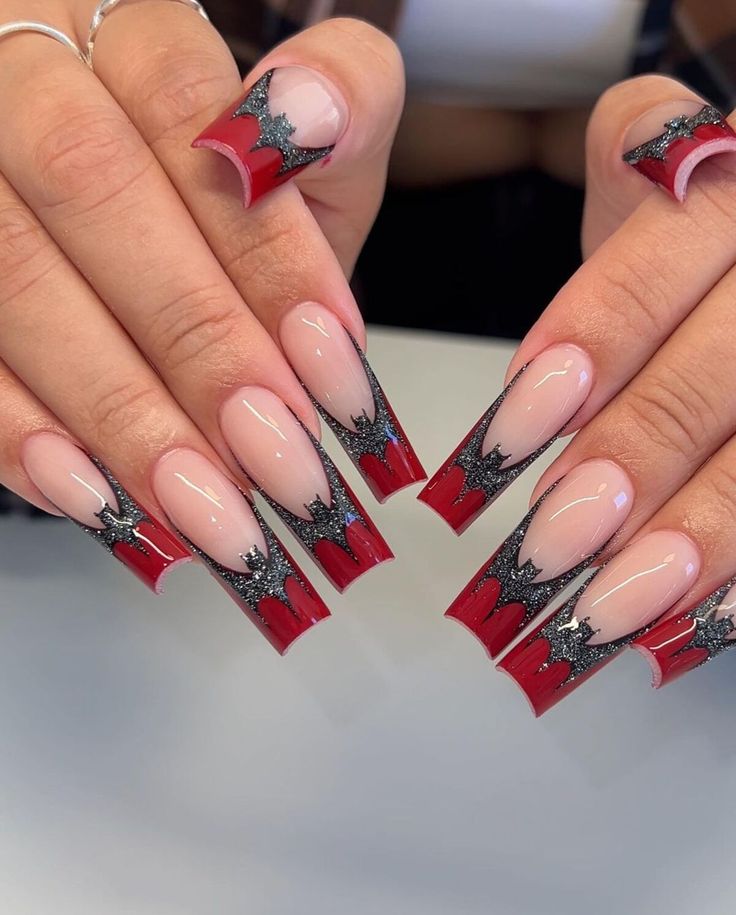 Bold and Chic Red and Nude Nail Design with Intricate Black Detailing.