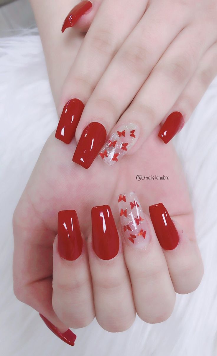 Chic Red Manicure: Glossy Finish with Whimsical Accent Nail.