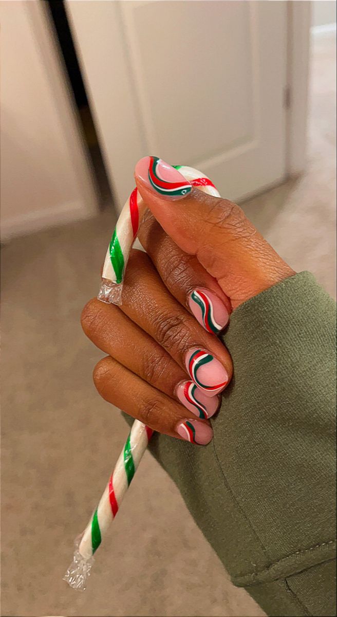 Cheerful Holiday Nail Design: Candy Cane Swirls on Soft Pink Base