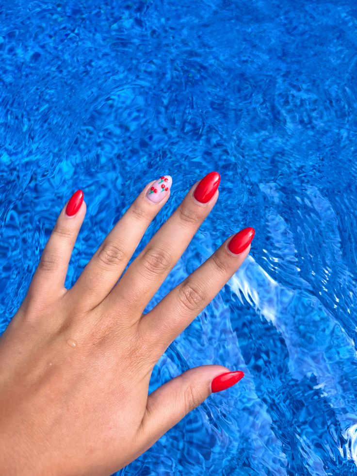 Bold Red Nails with Floral Accents Perfect for a Summer Poolside Aesthetic.