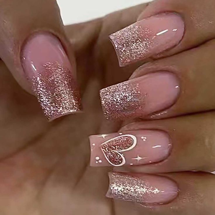 Charming Ombre Nail Design with Soft Pink Base, Shimmering Rose Gold Tips, and Heart Accent.