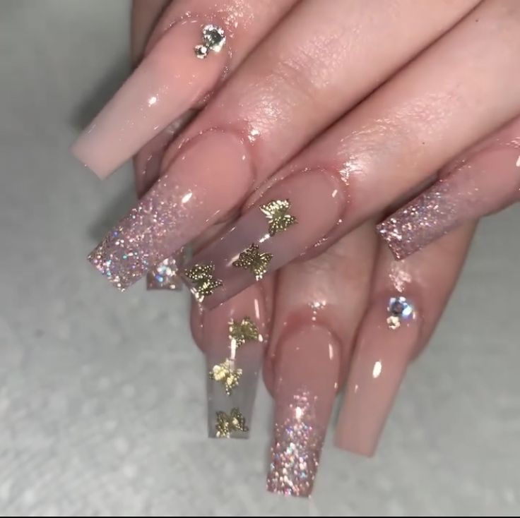 Sophisticated Long Acrylic Nails with Nude Base, Glitter Gradient, Gold Foil, and Rhinestone Accents.