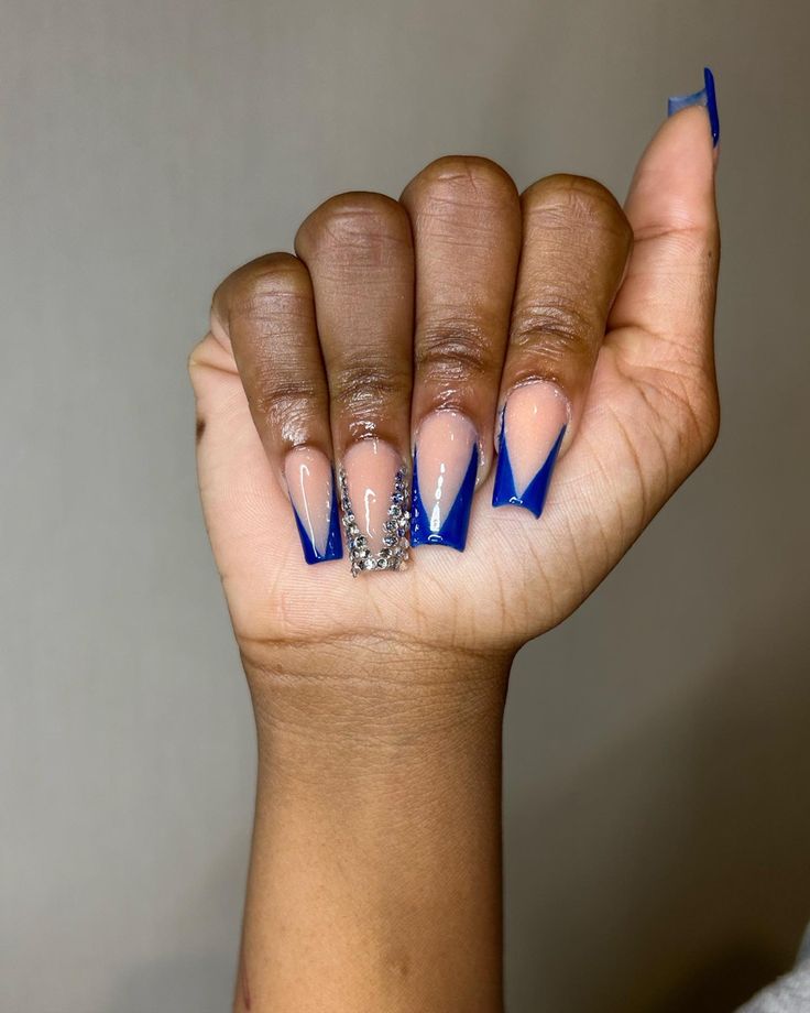 Elegant Almond-Shaped Nail Design: Bold Blue French Tips with Silver Accents.