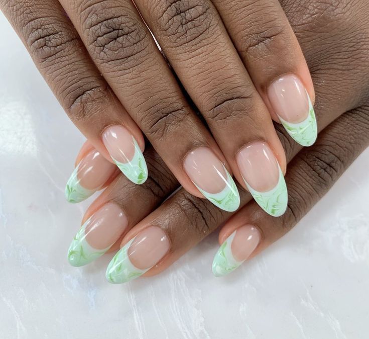 Chic Almond-Shaped Manicure with Nude Base and Vibrant Green Marble Tips.