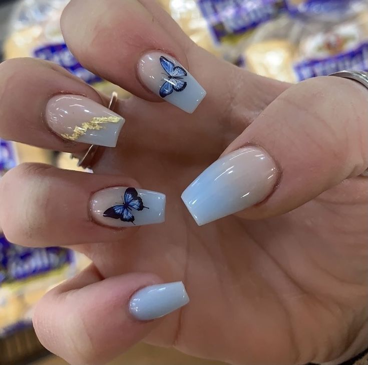 Whimsical Soft Blue Gradient Nail Design with Butterfly Accents for Spring/Summer.