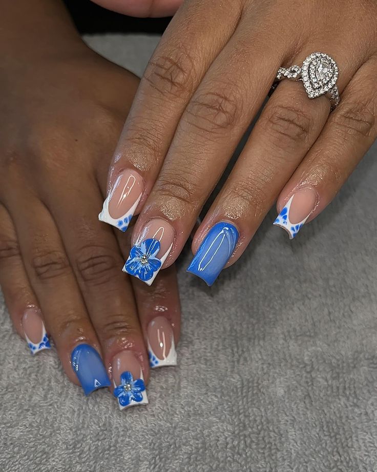 Sophisticated Blue Ombre Nail Design with Floral Accents and White Tips.