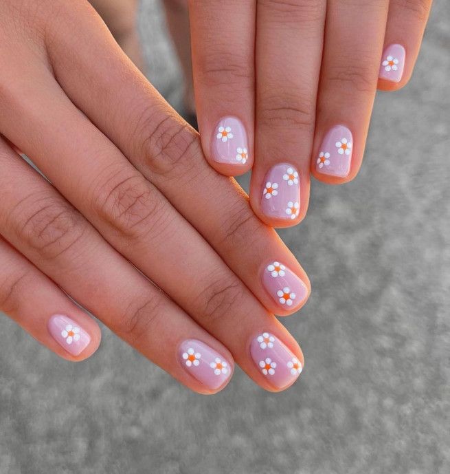 Delicate Floral Nail Design: Soft Pink Base with Cheerful Daisies for a Whimsical Spring/Summer Look.