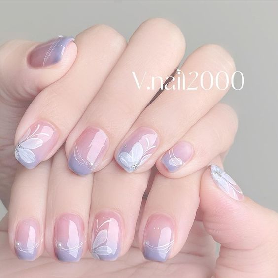 Elegant Lavender Ombre Nail Design with Floral Patterns and Sparkling Accents